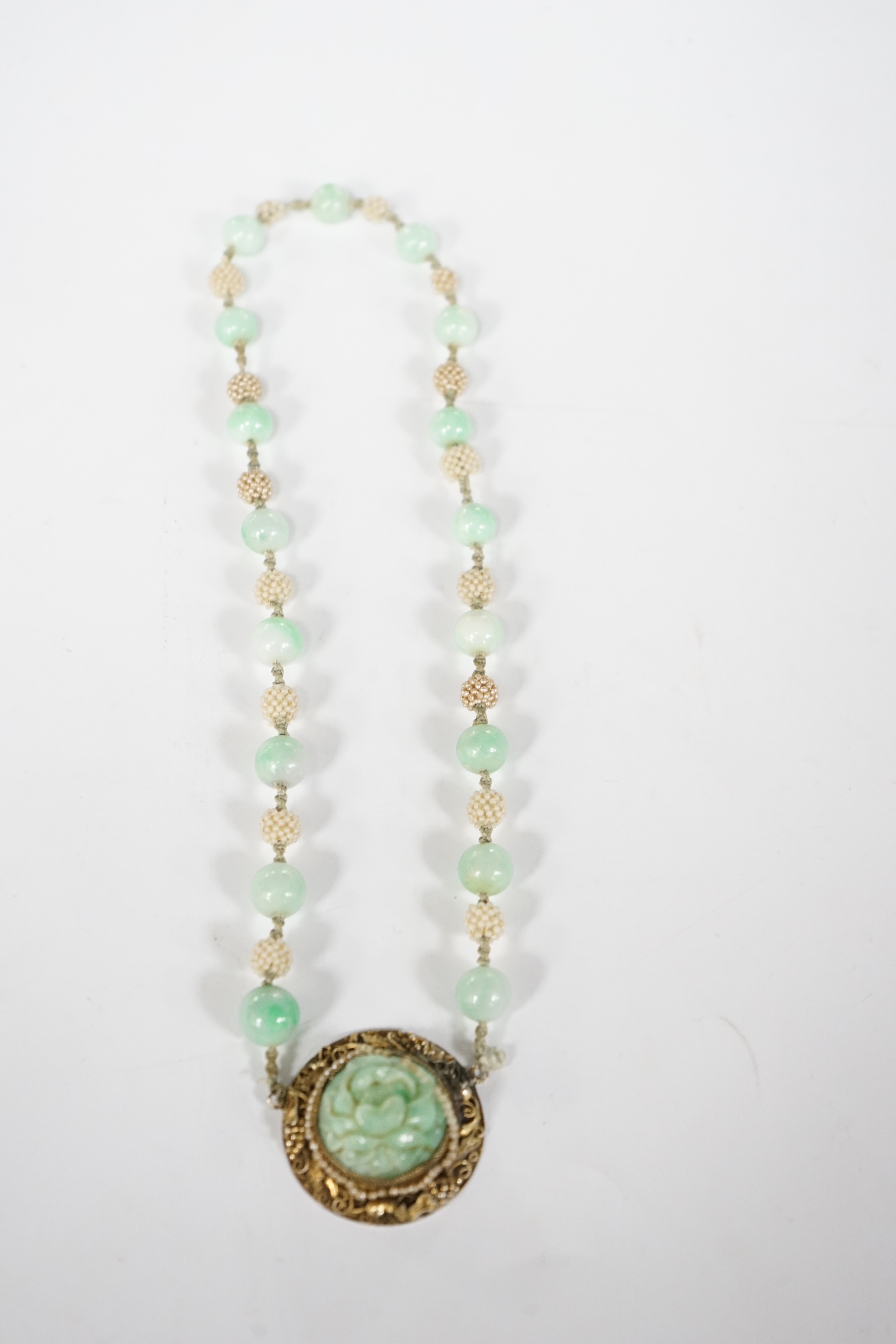 A Chinese late Qing jadeite and seed pearl choker necklace, carved jadeite and silver gilt pendant, 36cm